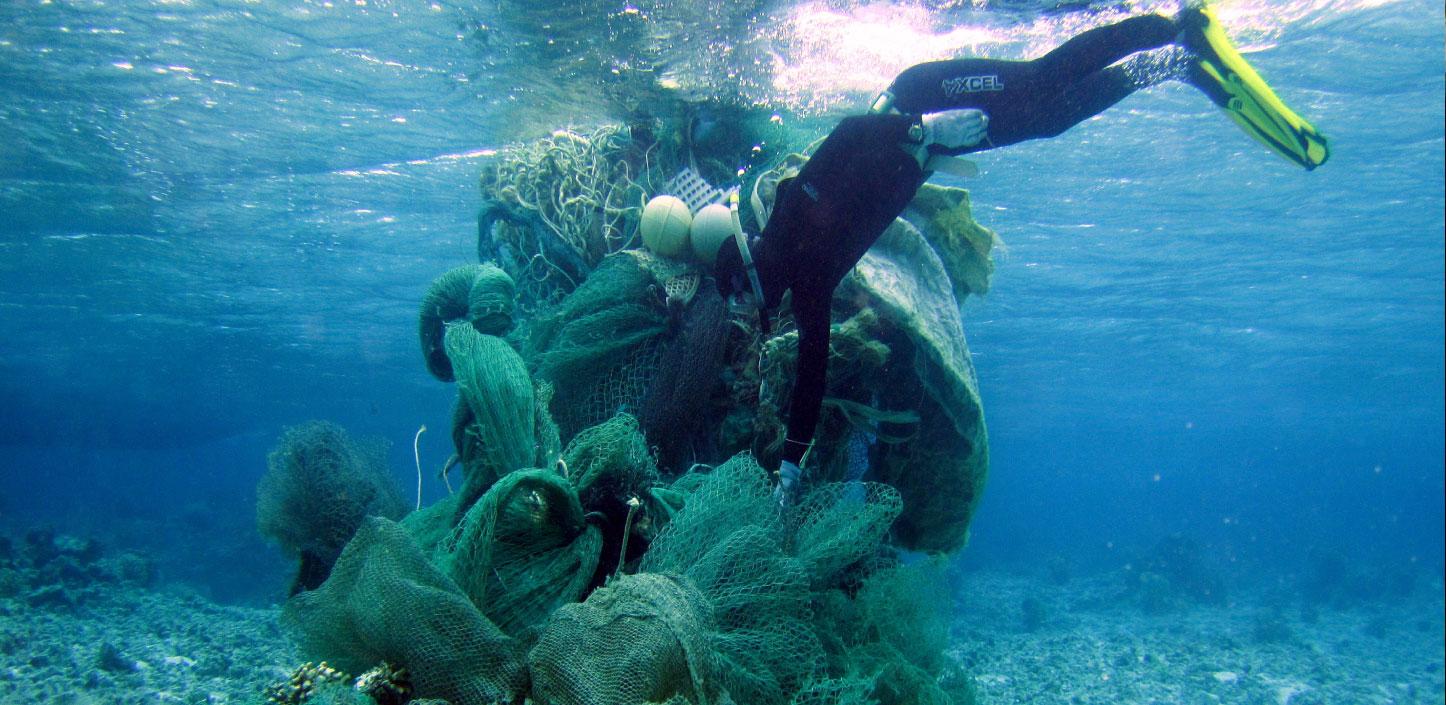 A marine debris removal diver conducts an assessment of a derelict net conglomerate at Midway Atoll, Northwestern Hawaiian Islands | Credit: JIMAR/NOAA PIFSC