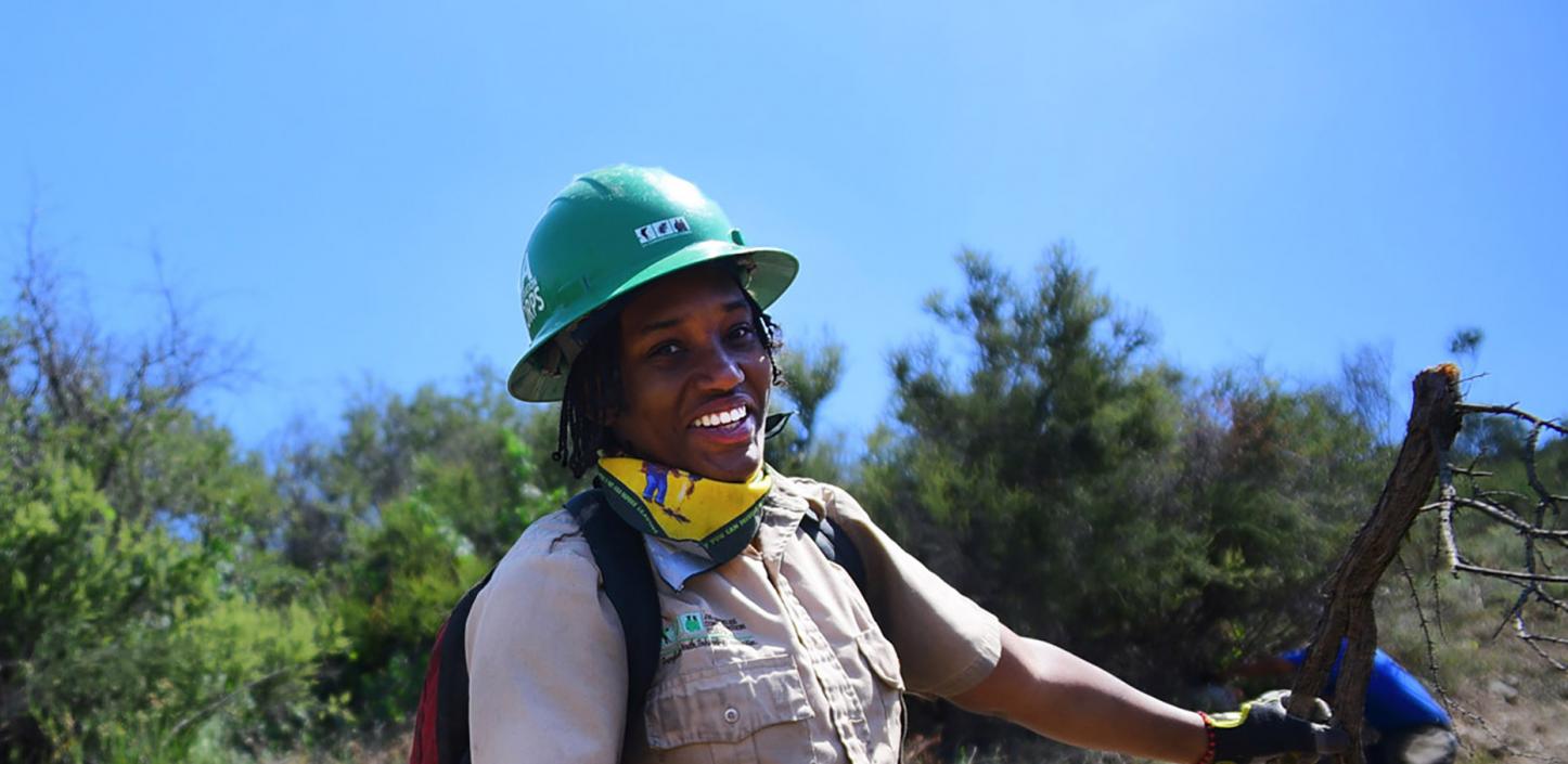 Youth corps member removing fire fuel