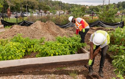 two men work on a raised garden bed on an urban farm