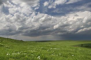 rolling tallgrass prairie hills with moody sky